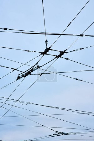 Photo for Image of Connecting wires for clean city transportation upward abstract view with overcast blue sky - Royalty Free Image