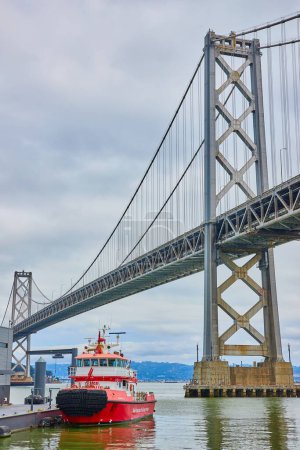 Foto de Imagen del día nublado sobre el Puente de Oakland Bay y el muelle y bote del Departamento de Bomberos de San Francisco - Imagen libre de derechos