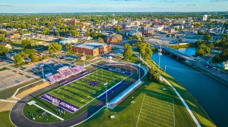 Photo for Image of Football game aerial Muncie Central Bearcats at sunset with city downtown buildings and White River - Royalty Free Image