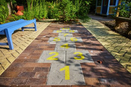 Photo for Image of Hopscotch kids game on brick path with yellow numbers at Minnetrista Museum and Gardens - Royalty Free Image