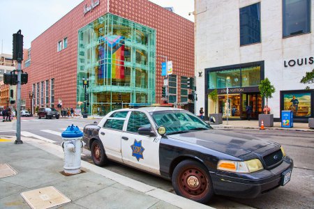 Photo for Image of SFPD patrol vehicle beside white and blue fire hydrant with rainbow pride flag in interior of building, San Francisco, CA - Royalty Free Image