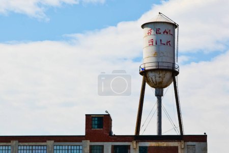 Téléchargez les photos : Iconic Real Silk château d'eau au sommet d'un bâtiment historique d'Indianapolis évoque une époque révolue de l'industrie américaine et la décomposition urbaine. - en image libre de droit