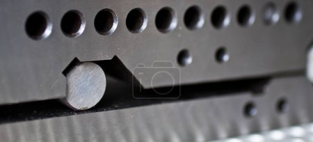 Photo for Precision engineering at its finest: A metal peg perfectly fits into a meticulously crafted hole, showcasing the exacting standards of manufacturing. Captured in Fort Wayne, Indiana. - Royalty Free Image