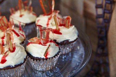 Téléchargez les photos : Délicieusement méchants, ces cupcakes sur le thème de l'Halloween comportent des éclats de sucre caramélisés et des bruines de sirop rouge sang. Parfait pour les célébrations effrayantes et les boulangers créatifs. - en image libre de droit