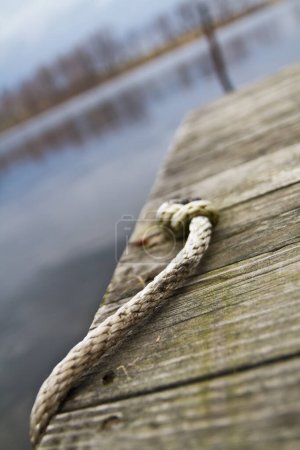 Téléchargez les photos : Paysage aquatique tranquille : Quai en bois altéré avec corde effilochée à Allegan, Michigan - en image libre de droit