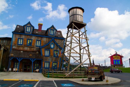 Photo for Whimsical and rustic themed attraction and dining venue, Hatfield and McCoy Dinner Show, in Gatlinburg, Tennessee. Featuring a cartoonish building with colorful shutters, a classic water tower, and a - Royalty Free Image
