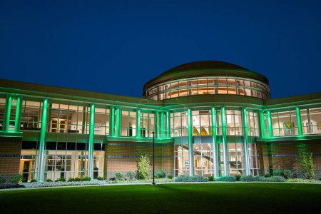 Photo for Modern architectural marvel illuminated with vibrant green lights at night, showcasing contemporary design and eco-friendly lighting. Located in Fort Wayne, Indiana, this urban gem blends nature and - Royalty Free Image