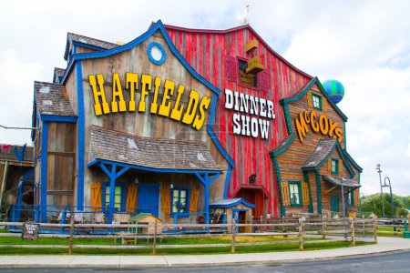 Téléchargez les photos : Façade colorée du bâtiment Hatfield and McCoy Dinner Show à Gatlinburg, Tennessee. Un dîner théâtral fantaisiste inspiré de la célèbre querelle américaine. Grange rouge vibrante avec jaune vif - en image libre de droit