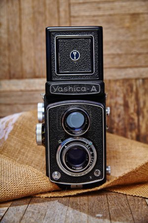 Foto de Vintage Yashica-A TLR Cámara sobre un fondo rústico de arpillera. Encanto nostálgico se encuentra con la mecánica intrincada de esta cámara de cine clásico. - Imagen libre de derechos