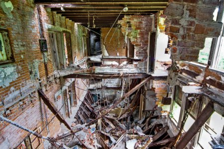Photo for Decaying remnants of Lima, Ohio TB Hospital reveal a hauntingly beautiful urban decay scene with crumbling architecture, exposed brick walls, and a collapsed wooden floor, capturing the passage of - Royalty Free Image