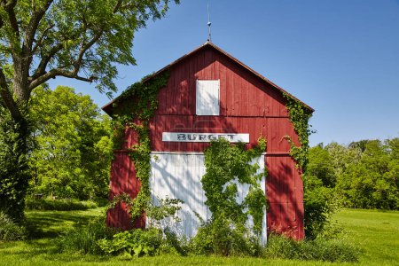 Téléchargez les photos : Grange rouge rustique avec panneau BURGET entourée de verdure luxuriante à Fort Wayne, Indiana - un charmant aperçu du patrimoine rural. - en image libre de droit