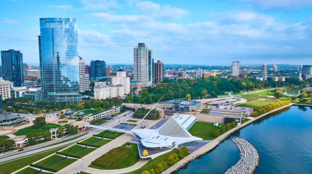 Foto de Vista aérea vibrante de un paisaje urbano moderno con un rascacielos de cristal, el artístico Quadracci Pavilion en Milwaukee y el lago Michigan, que muestra el crecimiento urbano y la sostenibilidad - Imagen libre de derechos