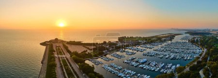 Foto de Vista aérea del bullicioso puerto de Burnham en Chicago, capturando el resplandor sereno del amanecer sobre el vibrante puerto deportivo y el horizonte de la ciudad - Imagen libre de derechos