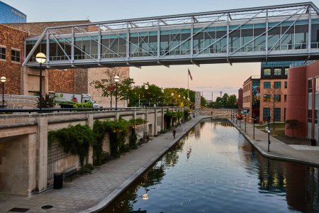 Photo for Modern pedestrian bridge reflecting on the tranquil canal at blue hour, downtown Indianapolis 2023, symbolizing urban development and serene city living. - Royalty Free Image