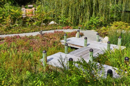 Téléchargez les photos : Chemin en bois serein au milieu d'une végétation luxuriante dans les jardins botaniques d'Elkhart, Indiana, reflétant un aménagement paysager respectueux de l'environnement et la tranquillité - en image libre de droit