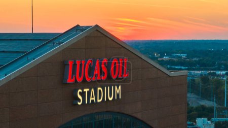 Photo for Twilight captures the iconic Lucas Oil Stadium sign, home of the Indianapolis Colts, with vibrant sunset colors contrasting the illuminated signage, set in an urban landscape. - Royalty Free Image