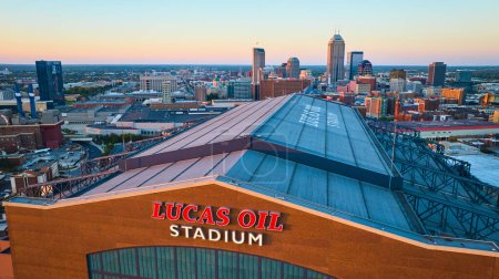 Téléchargez les photos : Vue de l'heure dorée du stade Lucas Oil avec toile de fond paysage urbain d'Indianapolis, capturé par drone en 2023 - en image libre de droit