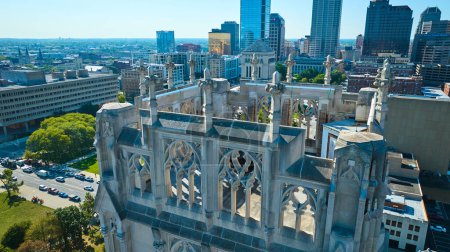 Photo for Aerial view of intricate gothic architecture of the Scottish Rite Cathedral contrasting with modern cityscape of Indianapolis, Indiana - Royalty Free Image