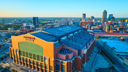 Téléchargez les photos : Golden Hour sur Lucas Oil Stadium, une merveille architecturale moderne au cœur du paysage urbain animé d'Indianapolis, capturé dans un superbe tir de drone. - en image libre de droit