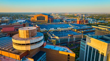 Photo for Golden Hour Over Indianapolis - Aerial view of the bustling cityscape with Lucas Oil Stadium, modern high-rises, and urban sprawl in 2023 - Royalty Free Image
