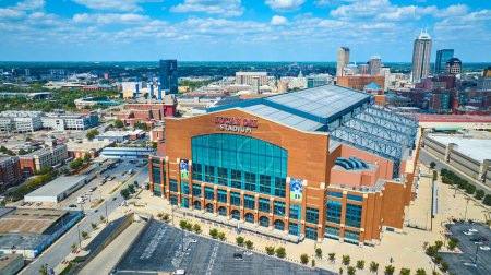 Téléchargez les photos : Vue aérienne du Lucas Oil Stadium à Indianapolis, une merveille architecturale moderne avec sa façade en brique rouge et son toit rétractable, situé dans un paysage urbain animé. - en image libre de droit