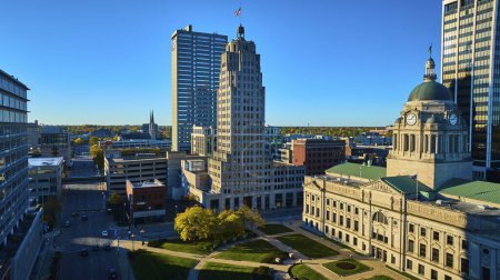 Foto de Vista aérea soleada de arquitectura diversa en el centro de Fort Wayne, Indiana, mostrando edificios históricos Art Deco y clásicos junto a rascacielos modernos - Imagen libre de derechos