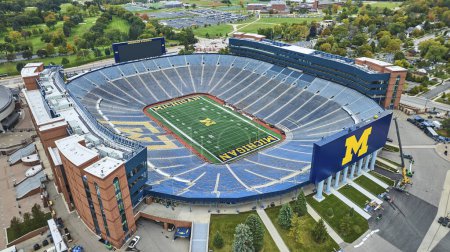 Téléchargez les photos : Vue aérienne du stade de football des Wolverines du Michigan à Ann Arbor, rempli de voitures garées pour une journée de match - en image libre de droit