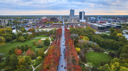 Photo for Aerial Sunrise View of Autumn Cityscape, Fort Wayne, Indiana - Vibrant fall colors adorn a tree-lined boulevard amidst urban architecture - Royalty Free Image