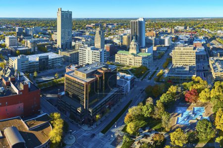 Téléchargez les photos : Vue aérienne du centre-ville animé de Fort Wayne, en Indiana, à l'automne, mettant en valeur une architecture diversifiée, une majestueuse capitale de l'État et un parc municipal automnal. - en image libre de droit