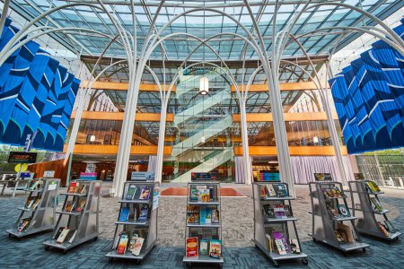 Téléchargez les photos : Intérieur dynamique et moderne de la bibliothèque à Indianapolis, 2023, présentant des expositions de livres attrayantes sous un grand plafond de verre - en image libre de droit