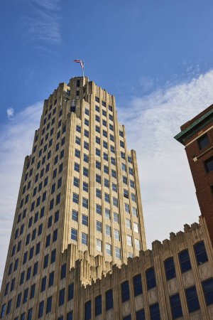 Art Deco architectural grandeur of the Lincoln Tower under clear blue skies in downtown Fort Wayne, Indiana, with a flying American flag