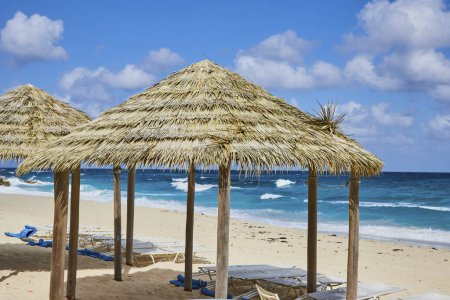 Téléchargez les photos : Escapade tropicale sur l'île de Nassau Paradise, Bahamas - Parapluies à toit de chaume et chaises longues sur une plage vierge avec vue sur l'océan - en image libre de droit