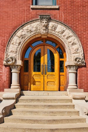 Téléchargez les photos : Grande porte en bois avec clé de voûte du lion et colonnes ornées dans un bâtiment en brique rouge, mettant en valeur l'architecture historique dans le centre-ville d'Indianapolis, 2023 - en image libre de droit