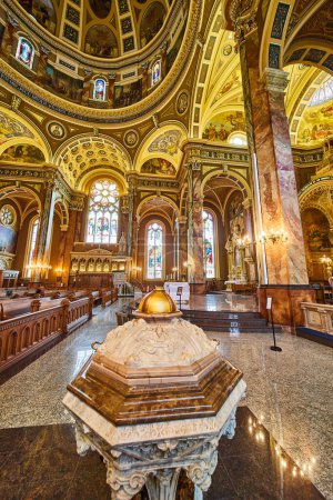 Téléchargez les photos : Luxueux intérieur de la basilique Saint-Josaphat à Milwaukee, avec chaire ornée, bancs polis menant à l'autel et fresques vibrantes sur les plafonds voûtés. - en image libre de droit