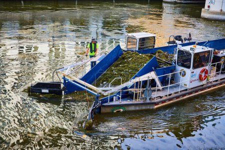 Foto de Operación de limpieza de ríos en Milwaukee, Wisconsin - Trabajador en buques especializados que limpian escombros, promoviendo la limpieza urbana y la administración ambiental, 2023 - Imagen libre de derechos