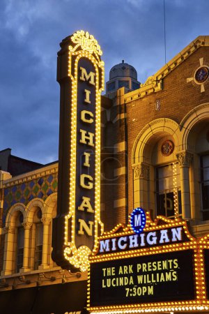 Foto de Marquesina del Teatro Michigan brillantemente iluminada que anuncia el evento Lucinda Williams, mostrando encanto vintage y detalle arquitectónico, contra el cielo crepuscular en Ann Arbor. - Imagen libre de derechos