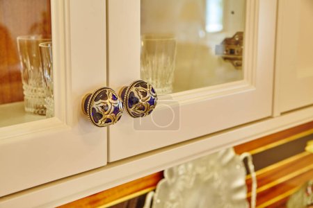 Téléchargez les photos : Boutons élégants de Cabinet bleu et or sur l'armoire à crème dans l'intérieur confortable de la maison de l'Indiana, 2015 - en image libre de droit