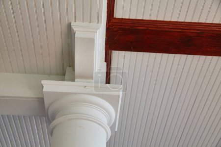 Klassische architektonische Details einer weißen Säule, einer Decke aus Perlbrett und einem dunklen Balken in Syracuse, Indiana, 2015