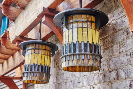Photo for Vintage-style wall-mounted lanterns on a rustic brick wall, casting a warm glow in a cozy outdoor setting in a 2015 Huntertown, Indiana residential architecture s. - Royalty Free Image