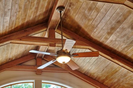 Photo for 2015 Indiana home featuring a vaulted wooden ceiling with a reversible blade ceiling fan and central light, designed s - Royalty Free Image