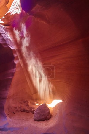 Photo for Sunbeam Pierces Slot Canyon in Arizona - A mystical dust-filled shaft of light illuminates the warm hues of Antelope Canyon, Sedona in 2016, highlighting the timeless beauty of this natural wonder. - Royalty Free Image