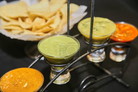 Téléchargez les photos : Variété de salsas mexicaines fraîches dans des bols en verre avec des chips de tortilla, présentées dans un restaurant à Fort Wayne, Indiana, 2017 - en image libre de droit