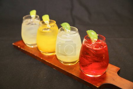 Lebendiger Verlauf der Cocktailauswahl, serviert auf einem Holztablett im Restaurant Indiana, 2017
