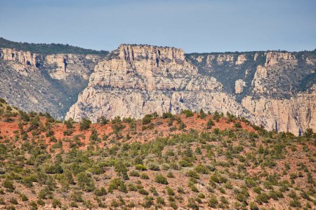 Foto de Impresionante vista diurna de acantilados estratificados y cordillera escarpada en Sedona, Arizona, 2016, mostrando capas geológicas y vegetación diversa. - Imagen libre de derechos