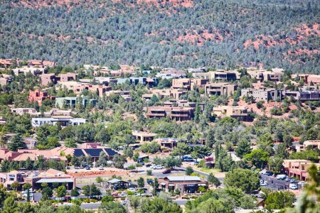 Southwestern-style residential neighborhood in Sedona, Arizona blending with natural landscape, captured under bright daylight with commercial activity in forefront, 2016