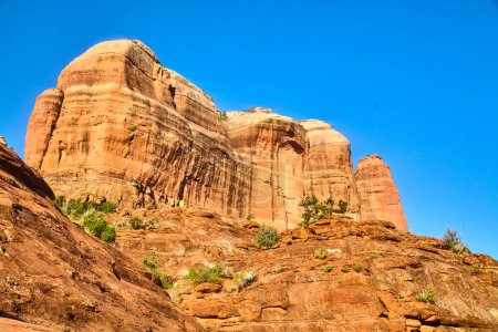 Foto de Majestic Cathedral Rock en Sedona, Arizona, se eleva bajo un cielo azul claro mostrando sus llamativos tonos rojos y anaranjados, rodeado de escasa vegetación del desierto, 2016. - Imagen libre de derechos