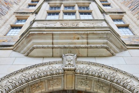 Elegant, historic stone architecture of University of Michigan Law Quadrangle in Ann Arbor, featuring detailed carvings and grand archway entrance