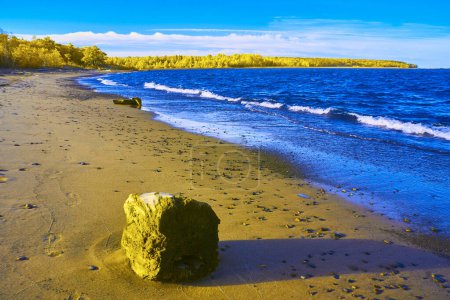 Sonniger Tag in Houghton Beach, Michigan: Verwitterter Fels, sanfte Wellen und üppiger Wald im Herbst 2017