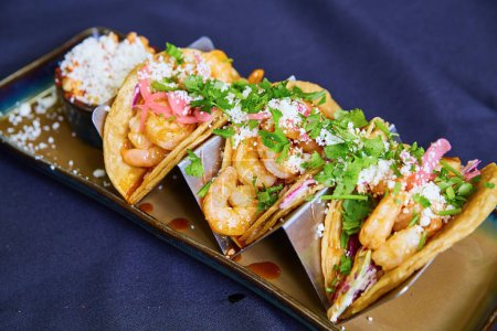 Vibrant shrimp tacos on blue tablecloth, a trendy culinary delight from a 2017 food event in Fort Wayne, Indiana
