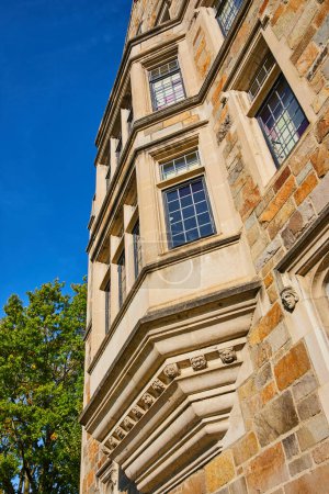 Sonnenbeschienene Ansicht des historischen University of Michigan Law Quadrangle, das komplizierte gotische architektonische Details vor einem strahlend blauen Himmel präsentiert